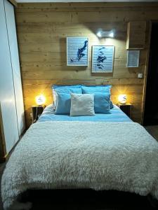 1 dormitorio con 1 cama grande con almohadas azules en Côté-Bourget 3 pers LA BELLE PLINIER proche La Norma Aussois, en Villarodin-Bourget