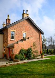 ein Backsteinhaus mit einer Seitentreppe in der Unterkunft Home Farm Cottage in Lytham St Annes