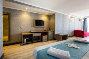 トラブゾンにあるMora Hotelのベッド1台、薄型テレビが備わるホテルルームです。