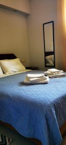 1 dormitorio con 1 cama con sábanas azules y espejo en Elia Guesthouse, en Kissamos