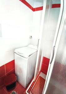 a small red and white bathroom with a washing machine at Elia Guesthouse in Kissamos