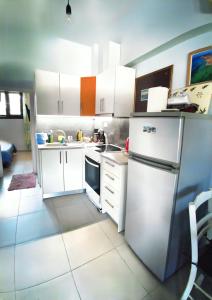 a small kitchen with white cabinets and a refrigerator at Elia Guesthouse in Kissamos