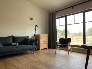 a living room with a couch and a chair at Ferienwohnung Pferdehof Birkholz 