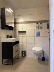 a bathroom with a white toilet and a sink at Ferienwohnung Pferdehof Birkholz in Bernau bei Berlin +17 photos