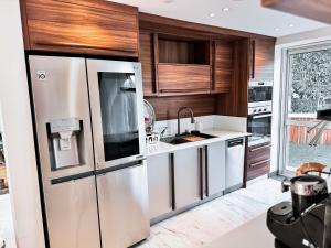 a kitchen with a stainless steel refrigerator and wooden cabinets at مدينتي in Madinaty