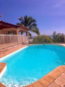 una gran piscina azul frente a una casa en Leu doux bruit des vagues, en Saint-Leu