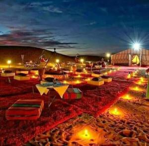 un grupo de sombrillas en una playa por la noche en Merzouga luxurious Camps en Merzouga