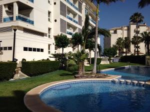 a swimming pool in front of a large building at Albir Apartment Lina in Albir