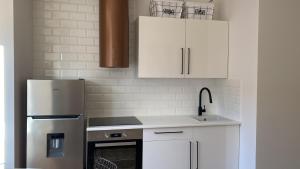 uma cozinha com armários brancos e um frigorífico de aço inoxidável em Studio in Žilina Bus Station em Žilina