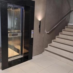an elevator in a building with a glass door at Executive Hotel in Lucas do Rio Verde