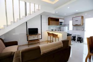 uma sala de estar com um sofá e uma cozinha em Encantos de Taperapuan Duplex em Porto Seguro