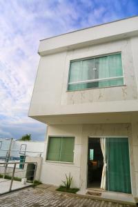 uma casa branca com uma cruz na lateral. em Encantos de Taperapuan Duplex em Porto Seguro