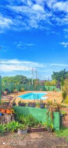 een zwembad met potplanten in een tuin bij Pousada Recanto das Maritacas in Brotas