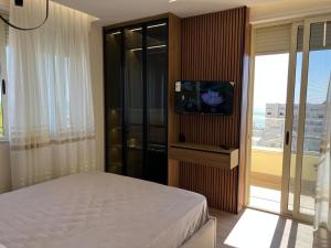 - une chambre avec un lit et une télévision à écran plat dans l'établissement Sunset Sea View - Premium Apartment 2BR, à Durrës