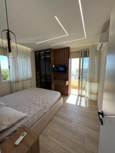 - une chambre avec un lit doté d'une télécommande dans l'établissement Sunset Sea View - Premium Apartment 2BR, à Durrës
