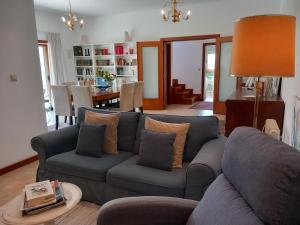a living room with a blue couch with pillows at Casa Douro Terrace in Baião