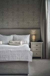 a bedroom with a white bed and a night stand at The Cults Hotel in Aberdeen