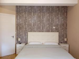a bedroom with a white bed and a wooden wall at La Cabana in Organyà