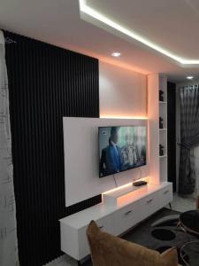 een woonkamer met een televisie aan de muur bij Sall Residence Mbour, Appartement 3 in Mbour