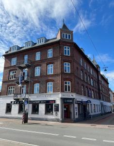 een groot bakstenen gebouw op de hoek van een straat bij Hotel Skandia in Helsingør