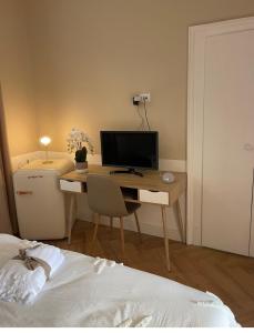 una camera con scrivania, computer e letto di Un piccolo rifugio d’élite a Bergamo