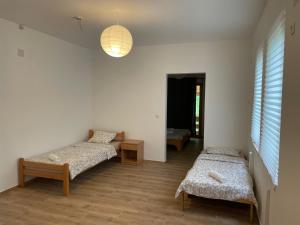 Cette chambre comprend 2 lits et une lampe suspendue. dans l'établissement Camping Oaza, à Bela Crkva