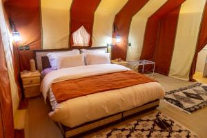 una camera con un grande letto di Zahra Luxury Desert Camp a Merzouga