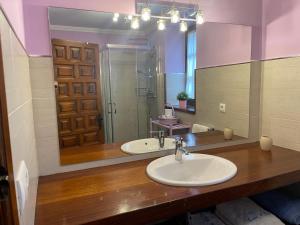 a bathroom with two sinks and a large mirror at La Casina de Mon in Quintana de Llanes