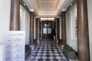 un couloir d'un bâtiment avec colonnes et porte dans l'établissement Glam Luxury Rome, à Rome
