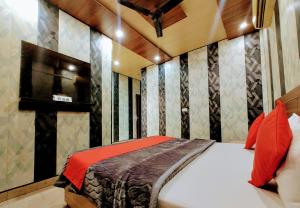 a bedroom with a bed and a tv on the wall at Hotel Grand in Zirakpur