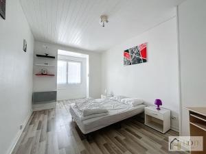 a white bedroom with a bed and a wooden floor at Les Dunes Marines - Appart 3e Étage Proche Plage & Commerces in Bray-Dunes +8 photos