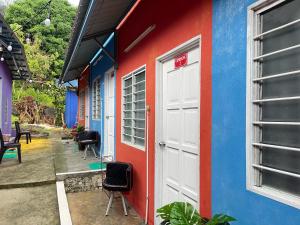 a blue and red building with a white door at Memory Lane Tioman in Tioman Island