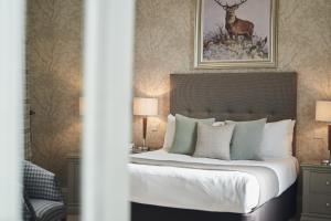 1 dormitorio con 1 cama con una pintura de ciervo en la pared en The Cults Hotel, en Aberdeen