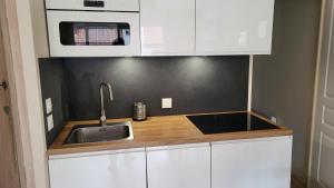 a kitchen with a sink and a microwave at Le Repère des Surfeurs in Wissant