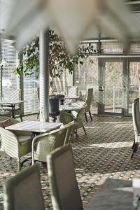 an empty restaurant with tables and chairs and windows at The Cults Hotel in Aberdeen