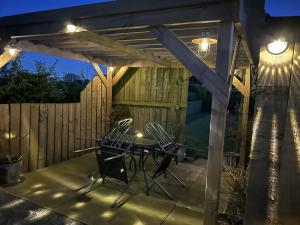 a patio with a table and chairs under a pergola at High Oak Holiday Cottage in Thirsk