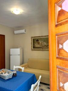 Casa Vacanze Villa Angelina في جيارديني ناكسوس: غرفة معيشة مع طاولة وأريكة