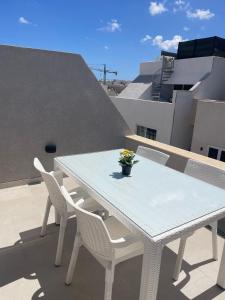 einen weißen Tisch und Stühle auf dem Balkon in der Unterkunft THREE BEDROOM APARTMENT SAN GWAN in San Ġwann