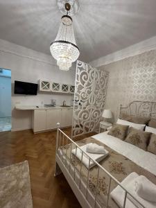 a bedroom with a large bed and a chandelier at UNIVERSITATE-ELEGANT-MIC DEJUN inclus in Bucharest