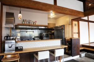 a large kitchen with a counter and some chairs at 小宿　福右衛門邸 in Kagoshima