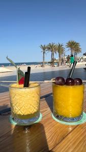 two glasses of fruit on a table near the beach at ALISA COSTA BLANCA in Platja de l'Arenal