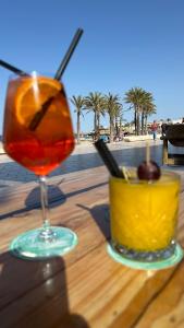a drink sitting on a wooden table next to a bowl of fruit at ALISA COSTA BLANCA in Platja de l'Arenal