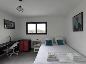 Schlafzimmer mit einem Bett, einem Schreibtisch und einem Fenster in der Unterkunft Maison d'Elina à 3 minutes de la mer in Vic-la-Gardiole