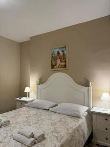 Casa Vacanze Villa Angelina في جيارديني ناكسوس: غرفة نوم بسرير كبير عليها منشفتين