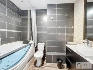 een badkamer met een bad, een toilet en een wastafel bij Dunes Sérénité: Calme & Confort Près Plage in Bray-Dunes