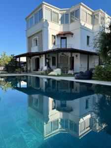 uma casa com o seu reflexo na água em Bodrum Merkezde Müstakil Havuzlu Villa em Bodrum City