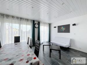 a dining room with a table and a desk and a clock at Dunes Sérénité: Calme & Confort Près Plage in Bray-Dunes