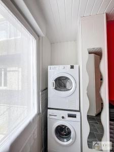 een wasmachine en een wasmachine in een kleine ruimte bij Dunes Sérénité: Calme & Confort Près Plage in Bray-Dunes