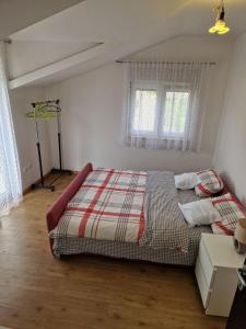 a bedroom with a bed and two windows at Apartman Sonja Trebinje in Trebinje +77 photos