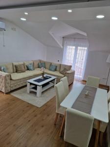 ein Wohnzimmer mit Sofa und Tisch in der Unterkunft Apartman Sonja Trebinje in Trebinje
